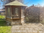 liebevoll gestalteter Holzpavillon mit integriertem Sitzbereich