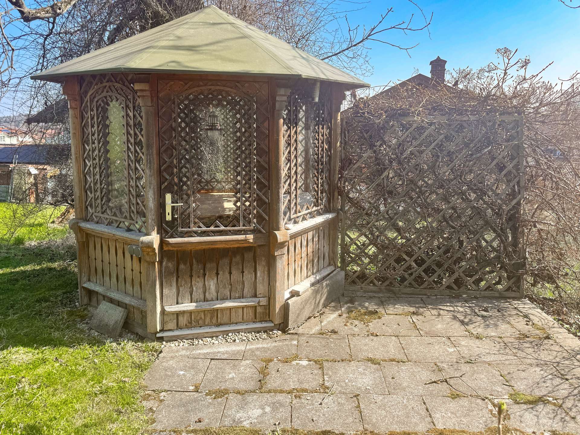 liebevoll gestalteter Holzpavillon mit integriertem Sitzbereich